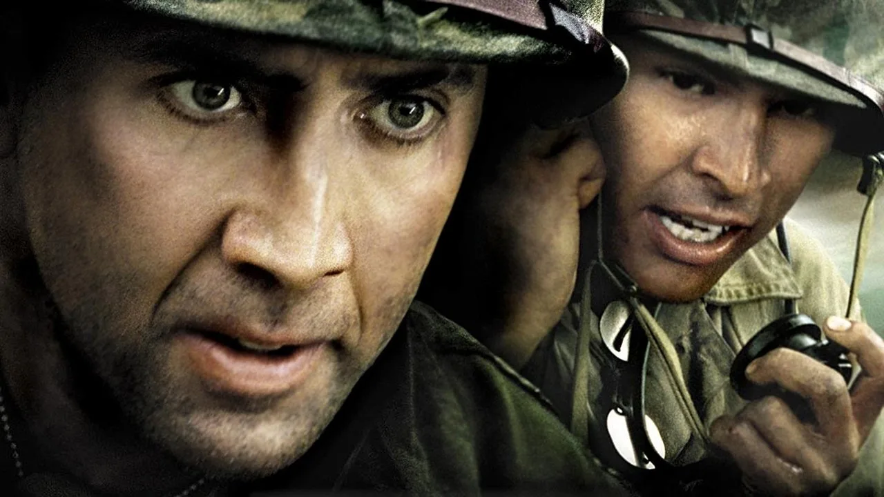 Nicolas Cage suado com fuzil e rádio na selva, destacando o vigor físico e a resistência muscular em cena de combate