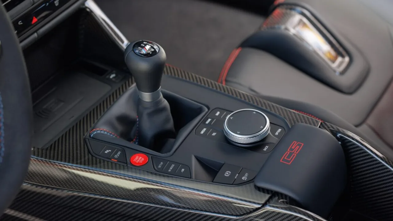 Close-up das mãos de um motorista trocando a marcha em um câmbio manual de couro dentro de um BMW M3 esportivo