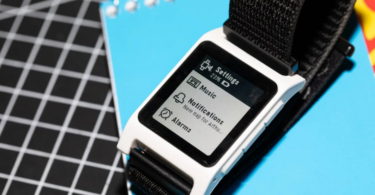 Pessoa correndo ao ar livre, usando smartwatch Pebble com tela e-paper exibindo batimentos cardíacos