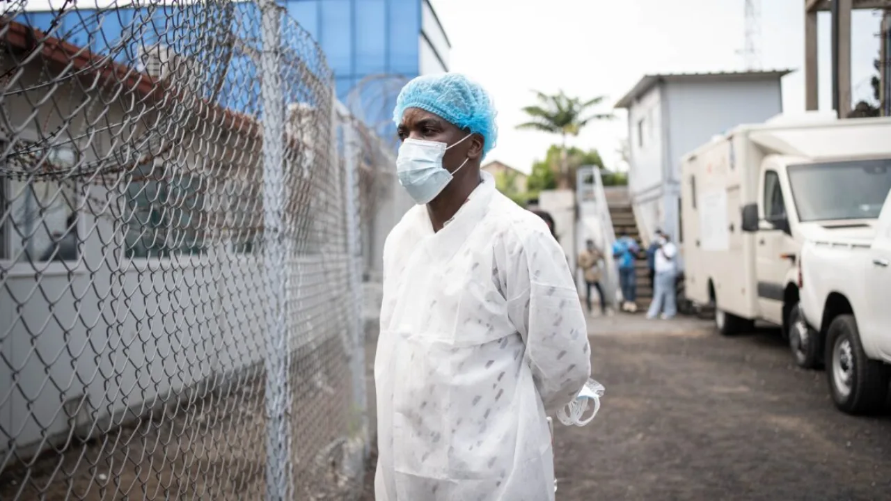 Médico com traje de proteção completo e estetoscópio, isolado em uma unidade de tratamento contra vírus em campo