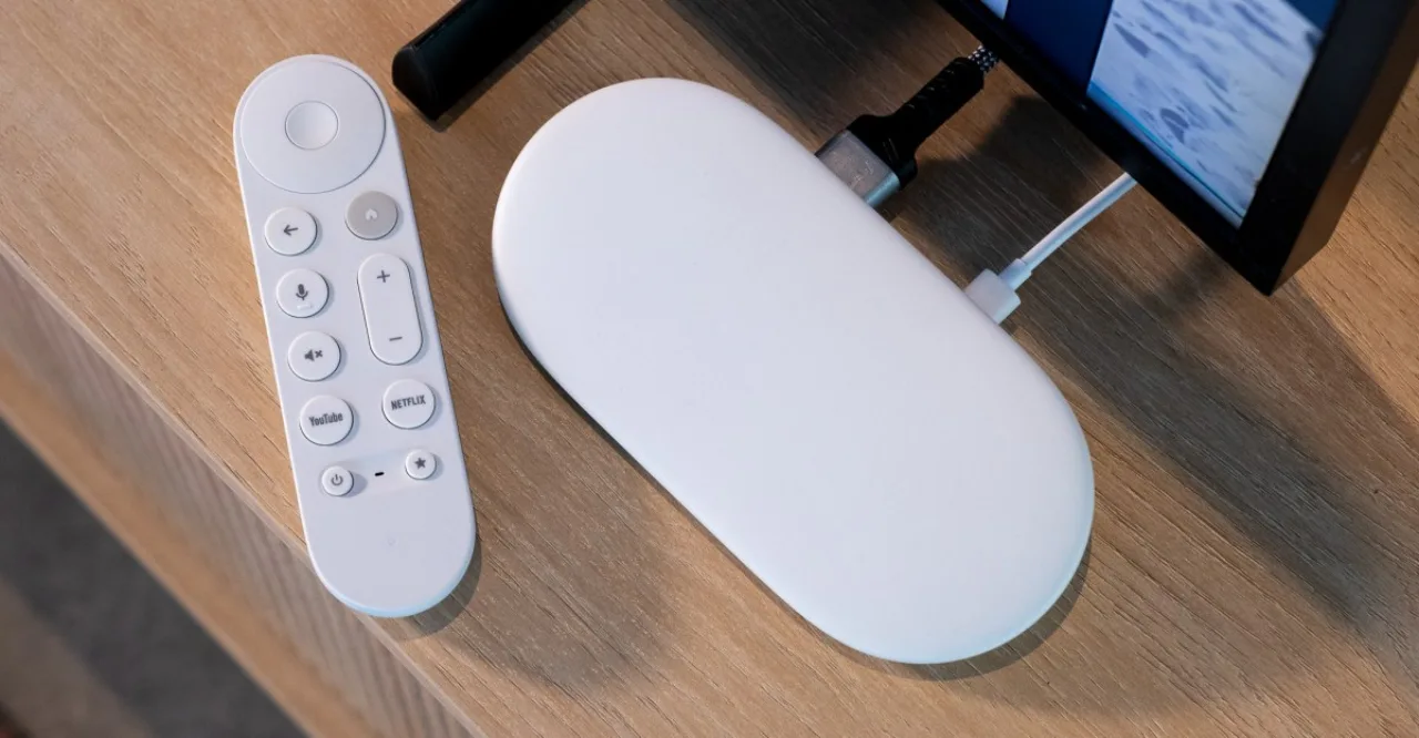 Jovem fazendo alongamento no sofá, segurando controle do Google TV ao lado da TV 4K exibindo app de fitness