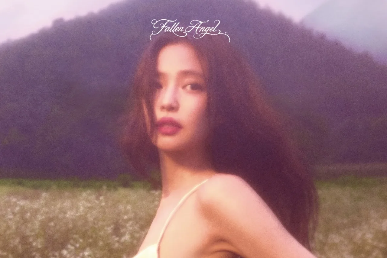 Jovem mulher faz agachamento usando fones pretos, com a capa do EP 'Fallen Angel' projetada ao fundo