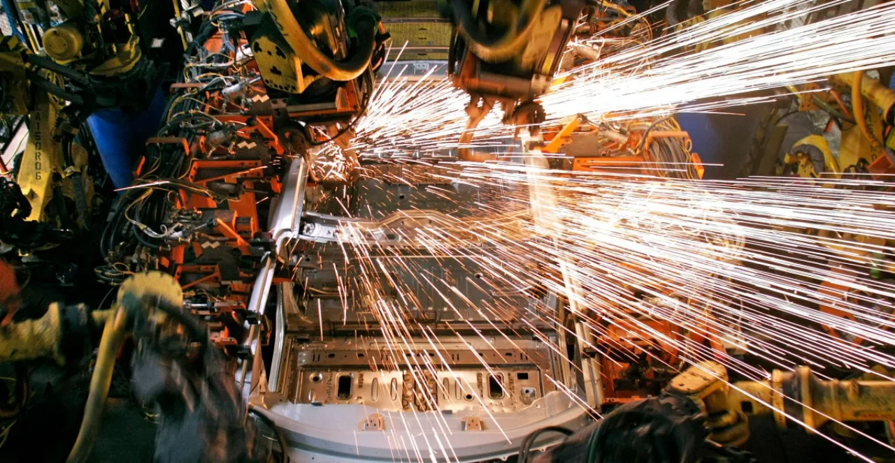 Carro da GM com design futurista, painel digital brilhante e braço robótico limpando a lataria