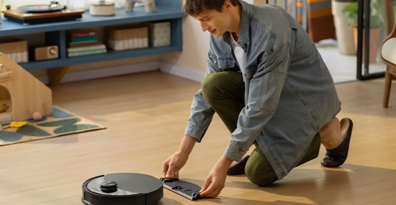 Robô aspirador Roborock Q10 S5 Plus deslizando sobre tapete claro ao lado de sofá moderno e mesa de centro