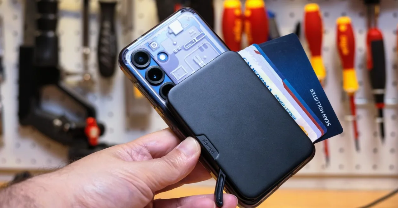 Carteira magnética OhSnap Wallet 2 de alumínio presa ao celular, exibindo a alavanca e módulos de cartões ao lado