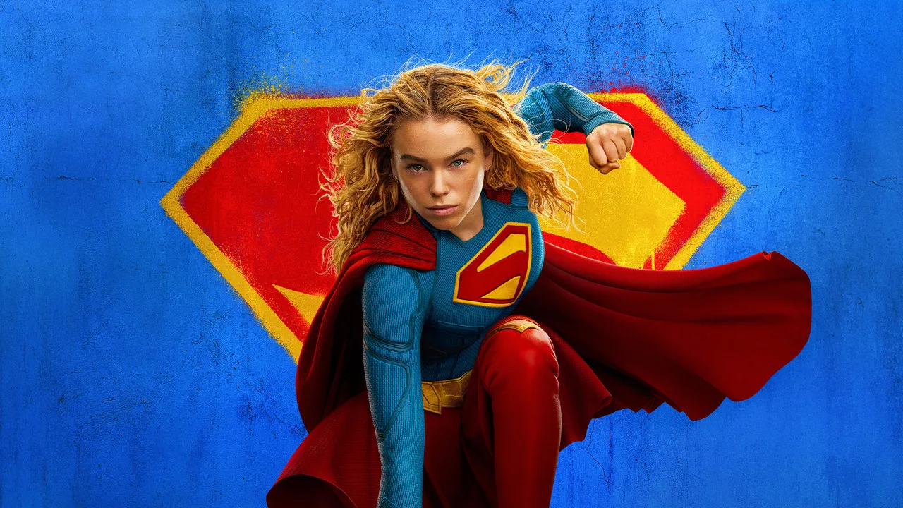 Supergirl em traje azul faz flexões com halteres enquanto um gráfico de bilheteria sobe ao fundo