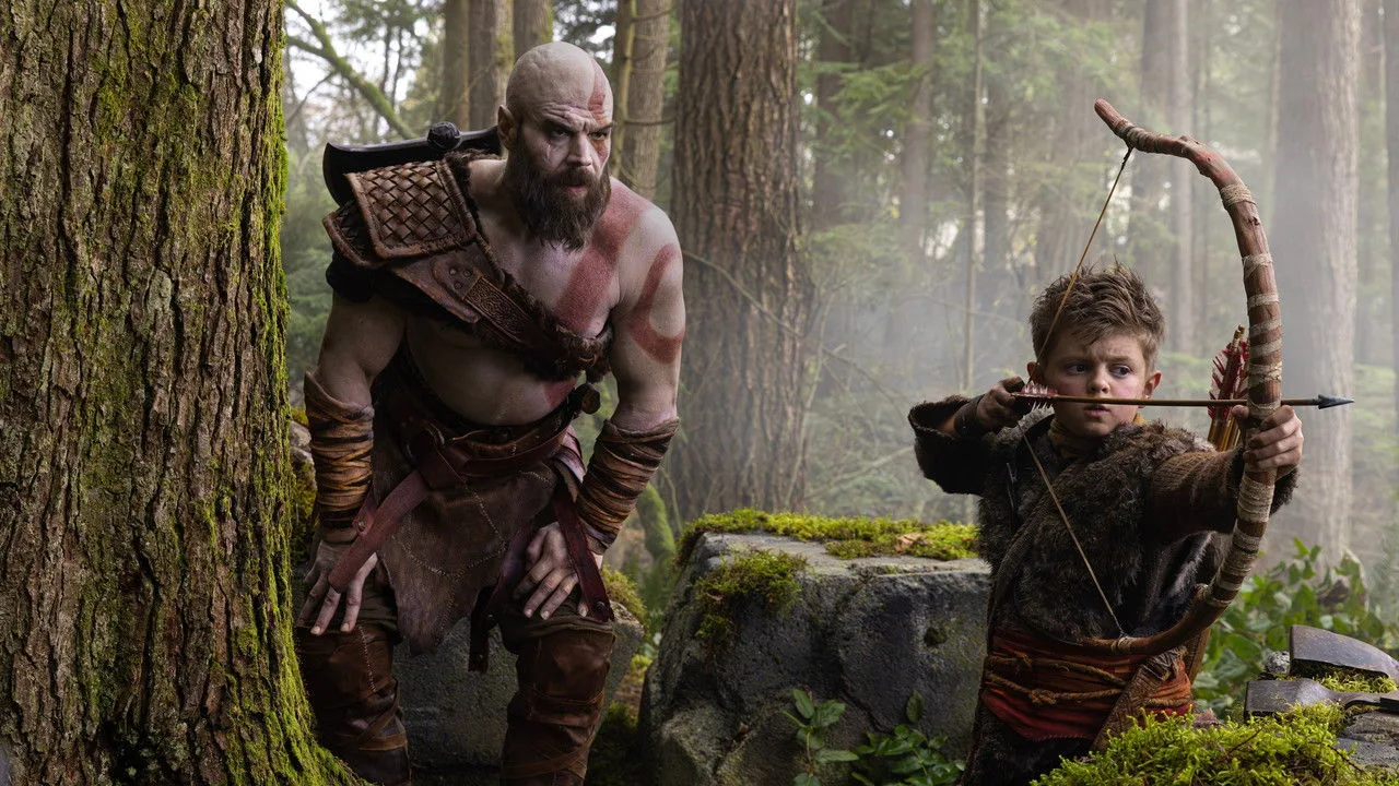 Dave Bautista faz supino com barra enquanto segura um elmo de Kratos ao lado de halteres e garrafas de água
