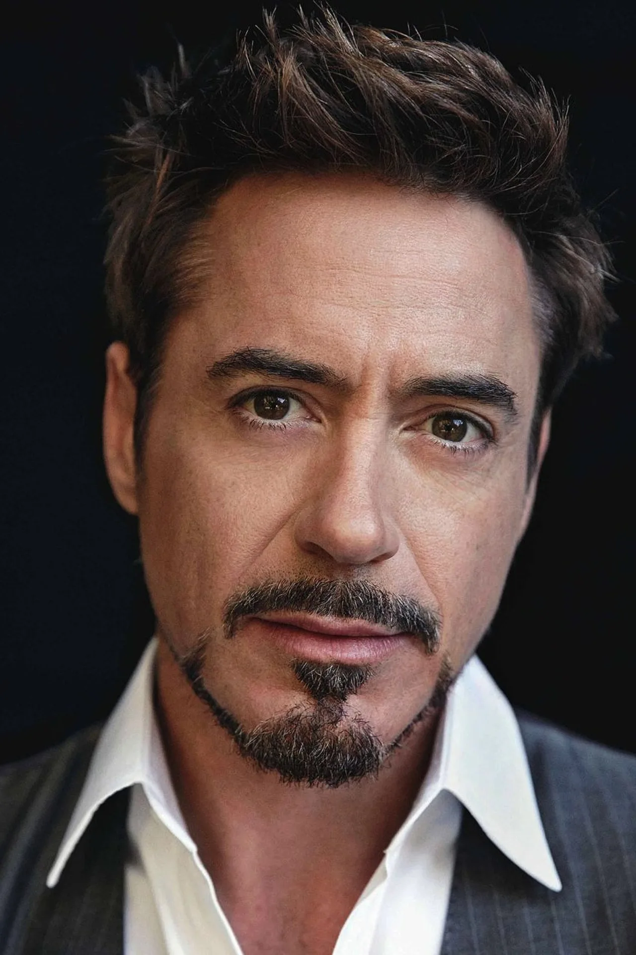 Homem em roupa de treino, segurando halteres, com máscara do Iron Man ao fundo