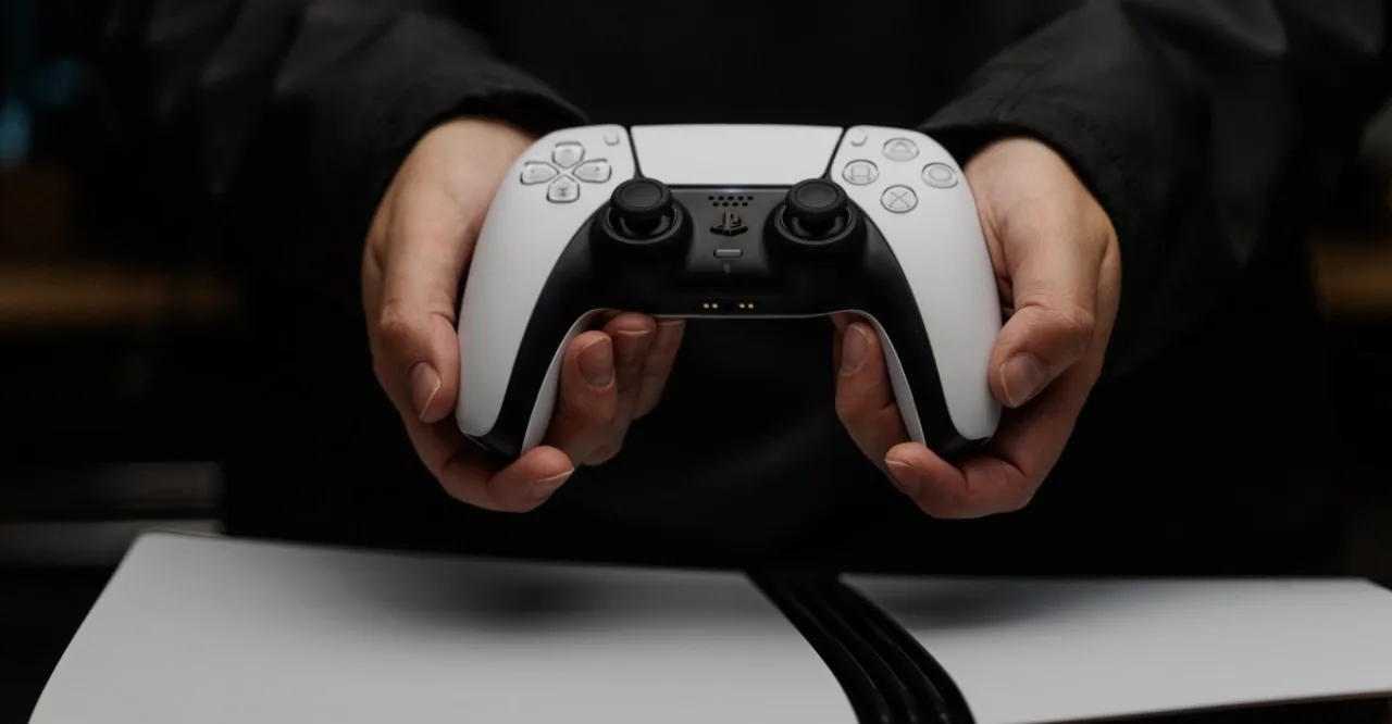 Console PlayStation 5 ao lado de um disco Blu‑ray com o logotipo da Sony ao fundo