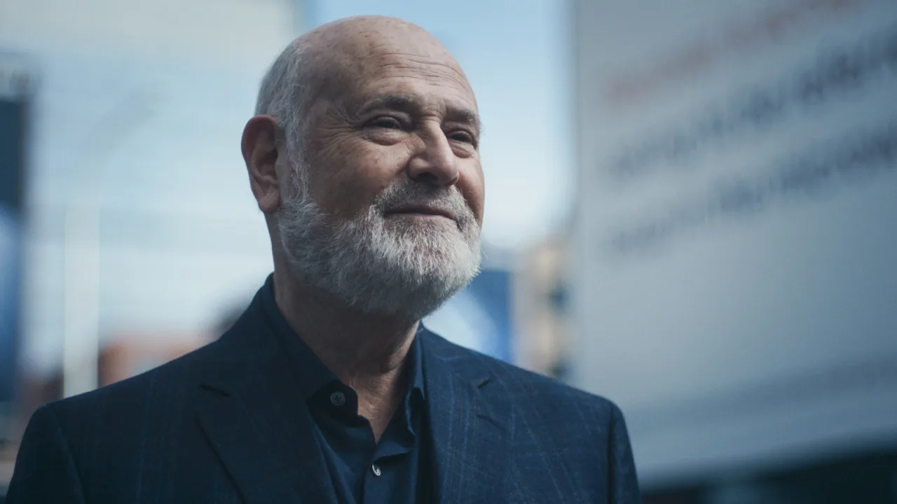 Mulher faz agachamento com barra enquanto assiste The Bear temporada 5 na TV ao fundo