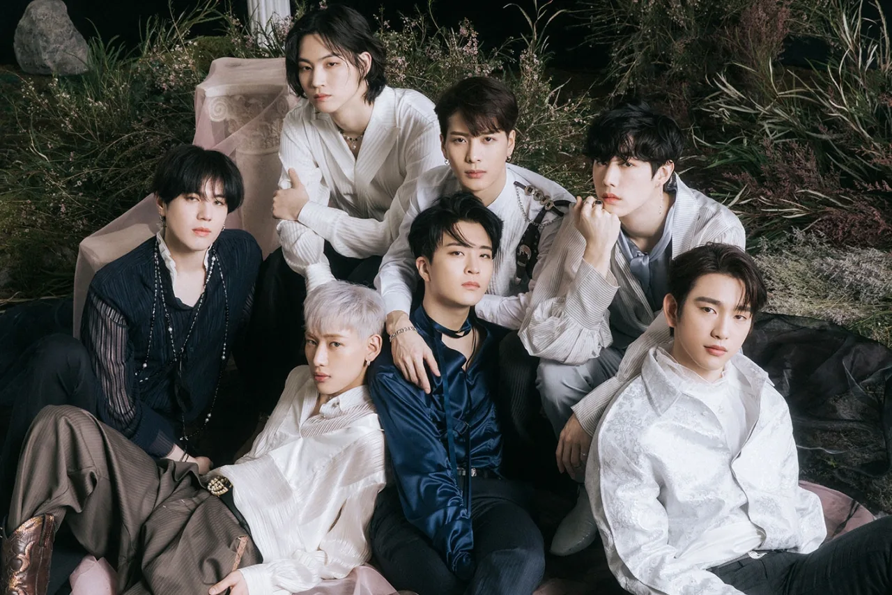 Membros do GOT7 posam ao lado do ícone do YouTube com a marca ‘100 milhões de visualizações’ sobre o clipe