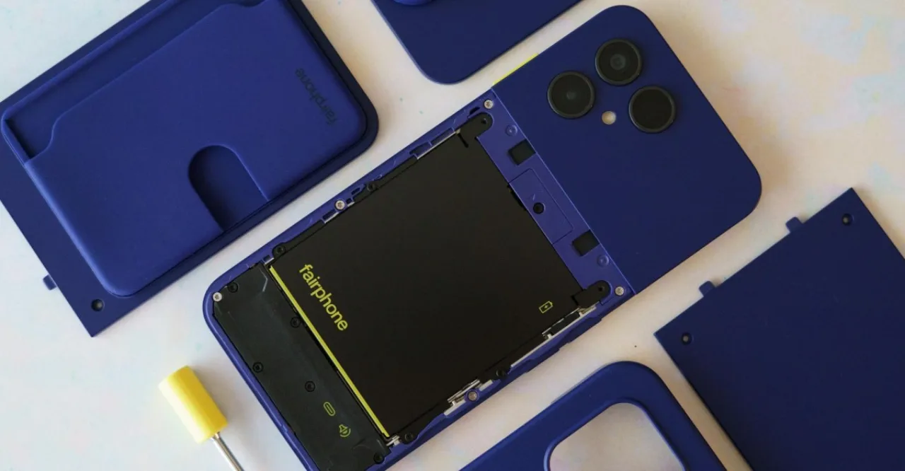 Mão segurando um Fairphone 6 Plus com módulos traseiros visíveis e fundo verde sustentável