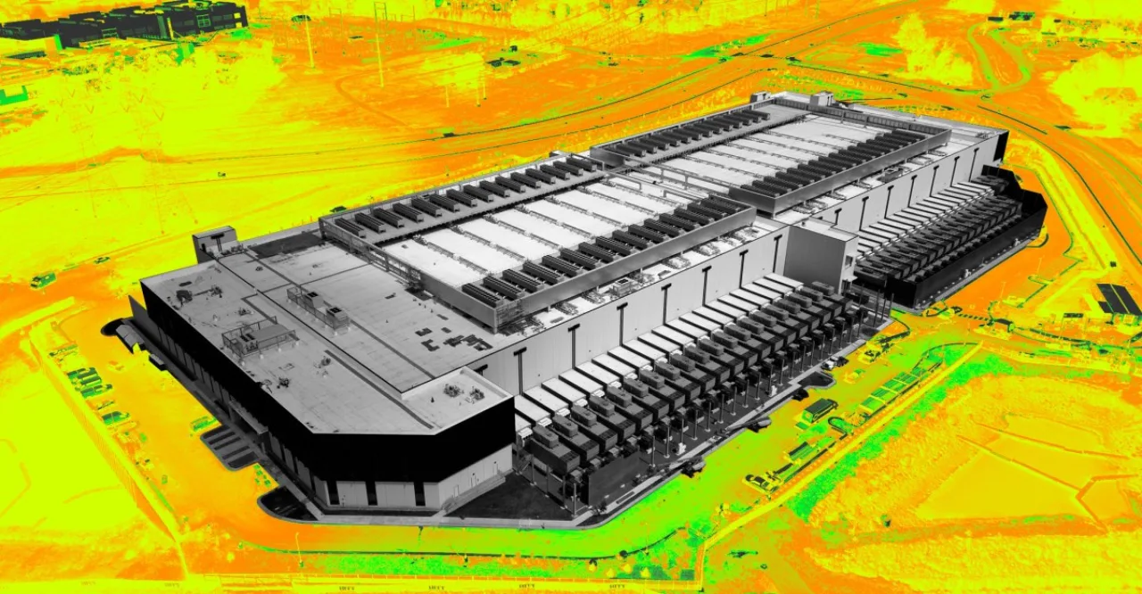 Atleta correndo ao ar livre enquanto nuvens de fumaça saem de um data center ao fundo