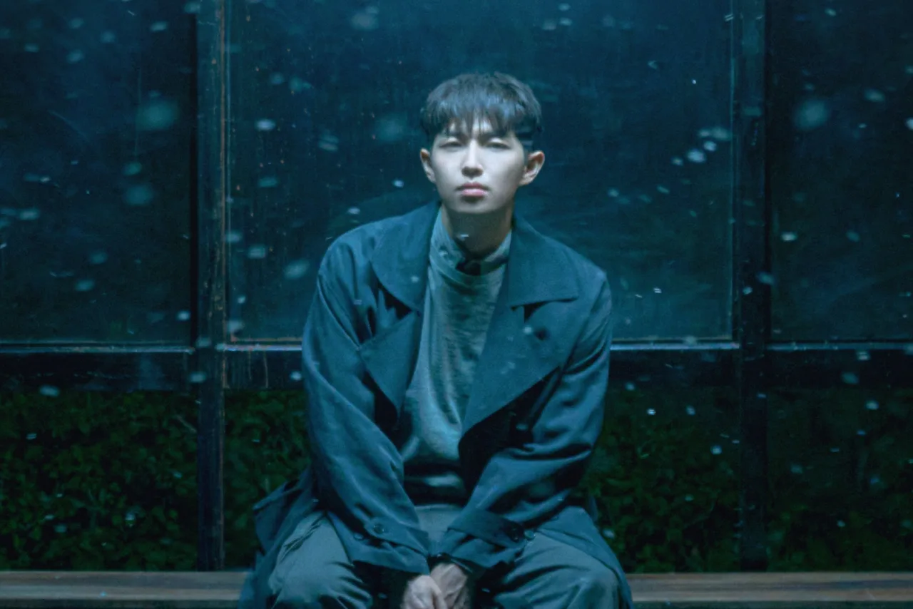 Kim Jae Hwan aparece de frente, vestindo jaqueta clara, com o título “Love, From Here” em letras rosa ao fundo
