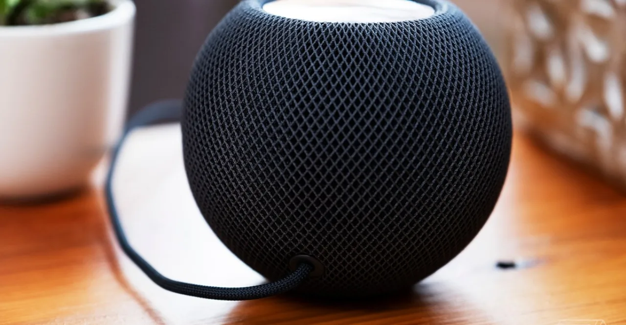 HomePod mini, iPad mini e Apple TV 4K ao lado de trechos de código e logotipo da Apple em fundo escuro