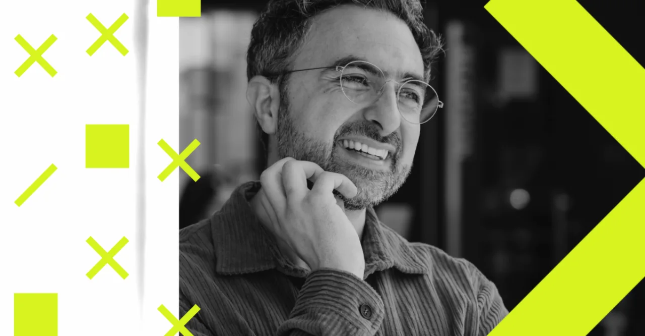 Mustafa Suleyman no palco, ao lado dos logos da Microsoft e Anthropic, com fundo de rede neural holográfica