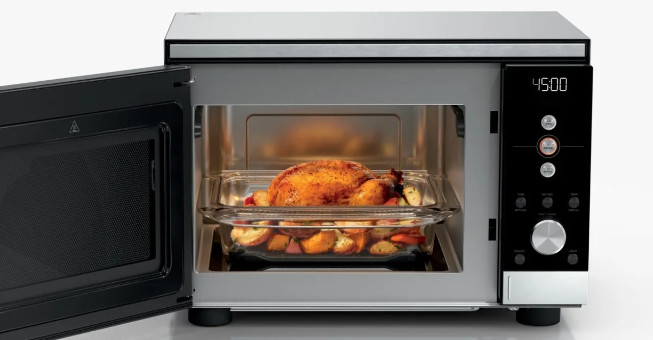 Ninja Crispi Microwave aberto, exibindo batatas fritas douradas e crocantes ao lado de um prato de salada verde