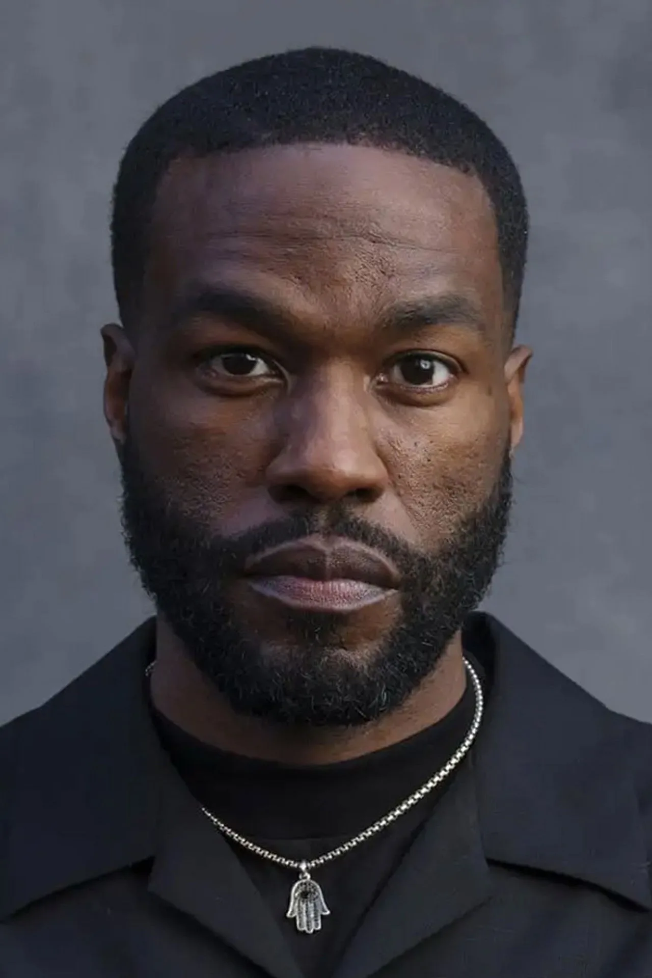 Yahya Abdul‑Mateen em roupa de treino, segurando halteres ao lado de uma garrafa d'água na academia