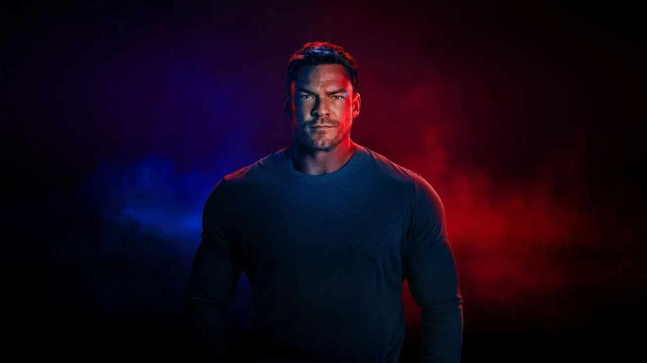 Alan Ritchson empurra trenó de peso pesado, suor visível, foco intenso