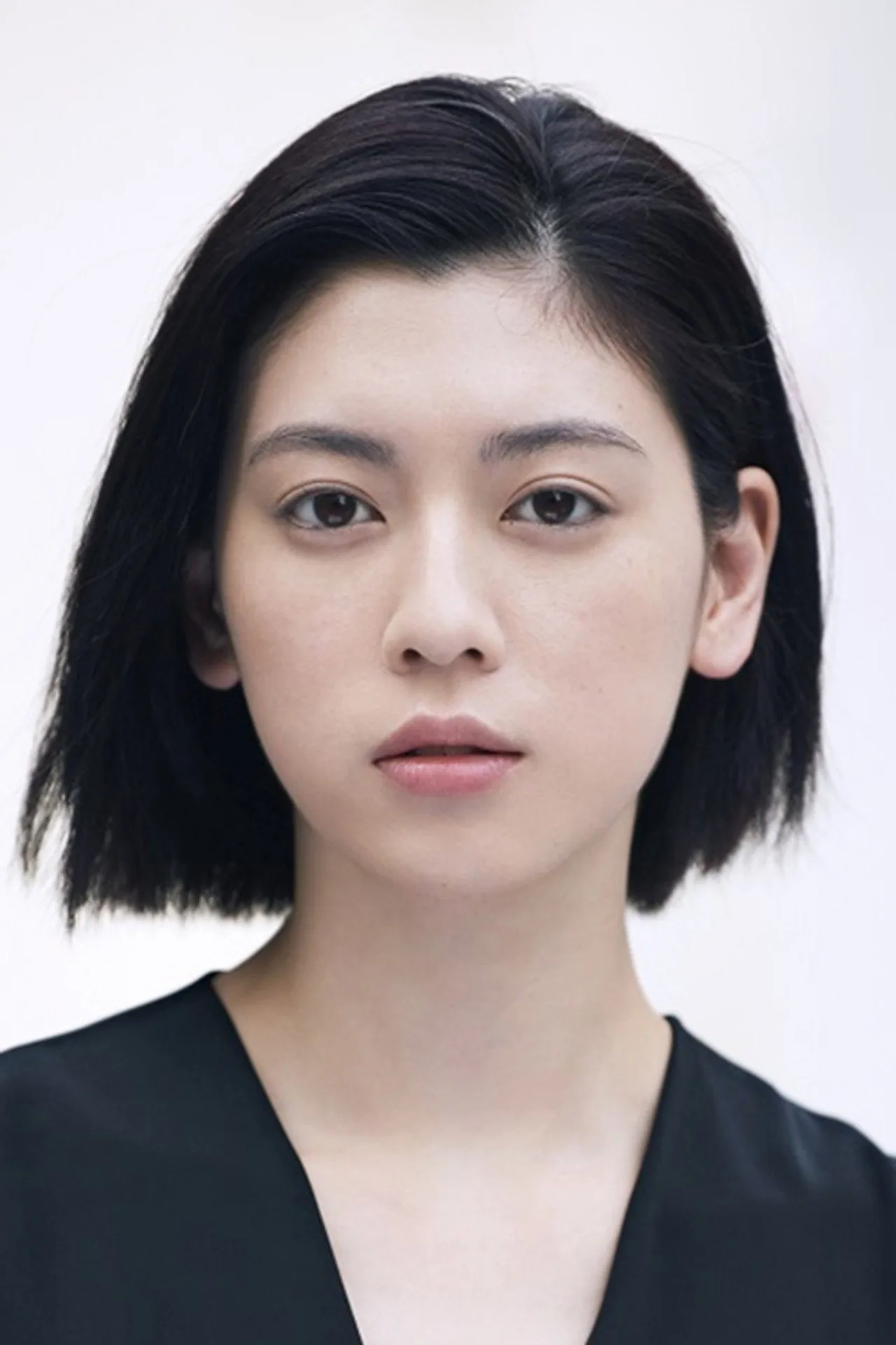 Ayaka Miyoshi vestindo traje executivo, segurando halteres, ao lado de uma caixa de sushi e um copo de chá verde