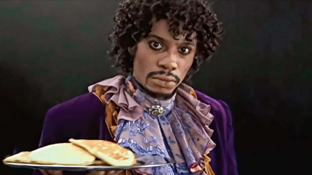 Homem em roupa de academia, sentado no tapete de yoga, segurando controle remoto e assistindo Chappelle’s Show no laptop