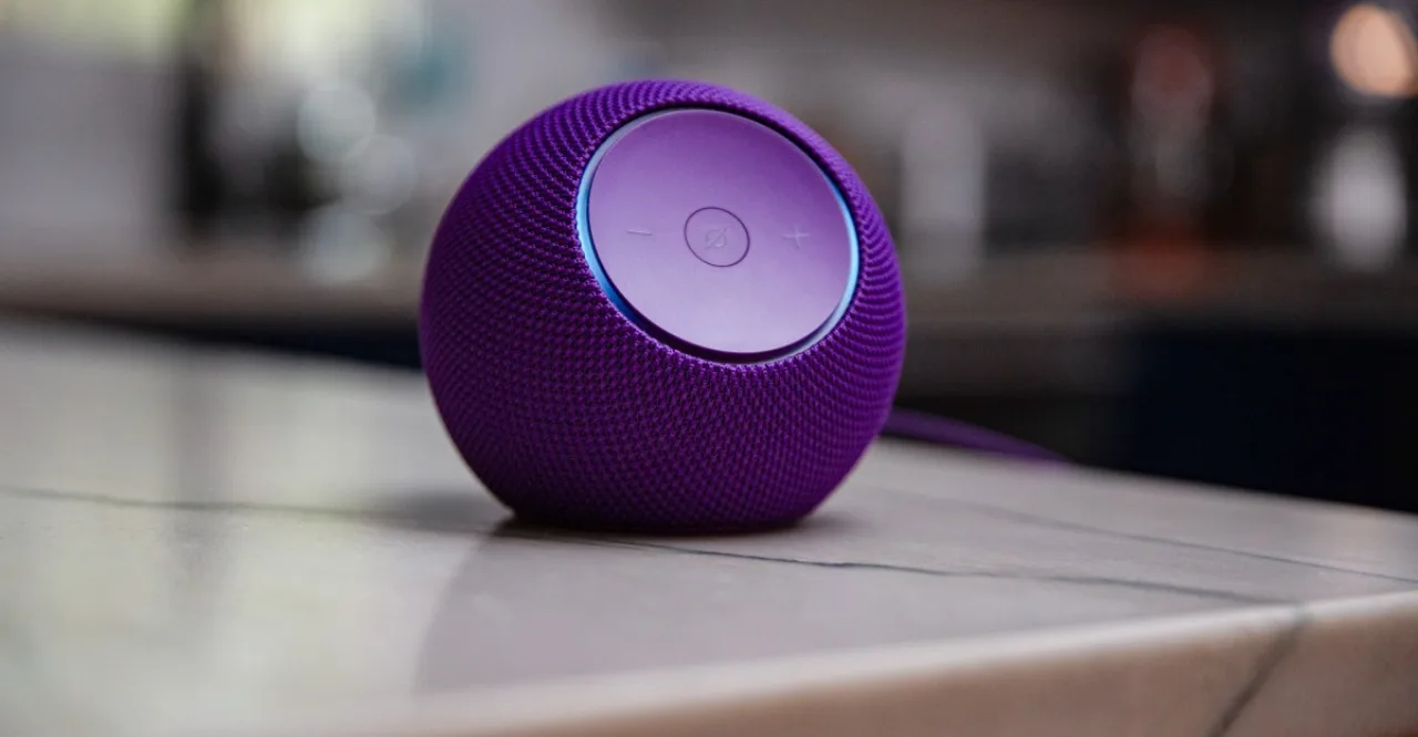 Jovem fazendo yoga, segurando Kindle Paperwhite e com Echo Dot ao fundo emitindo instruções de treino