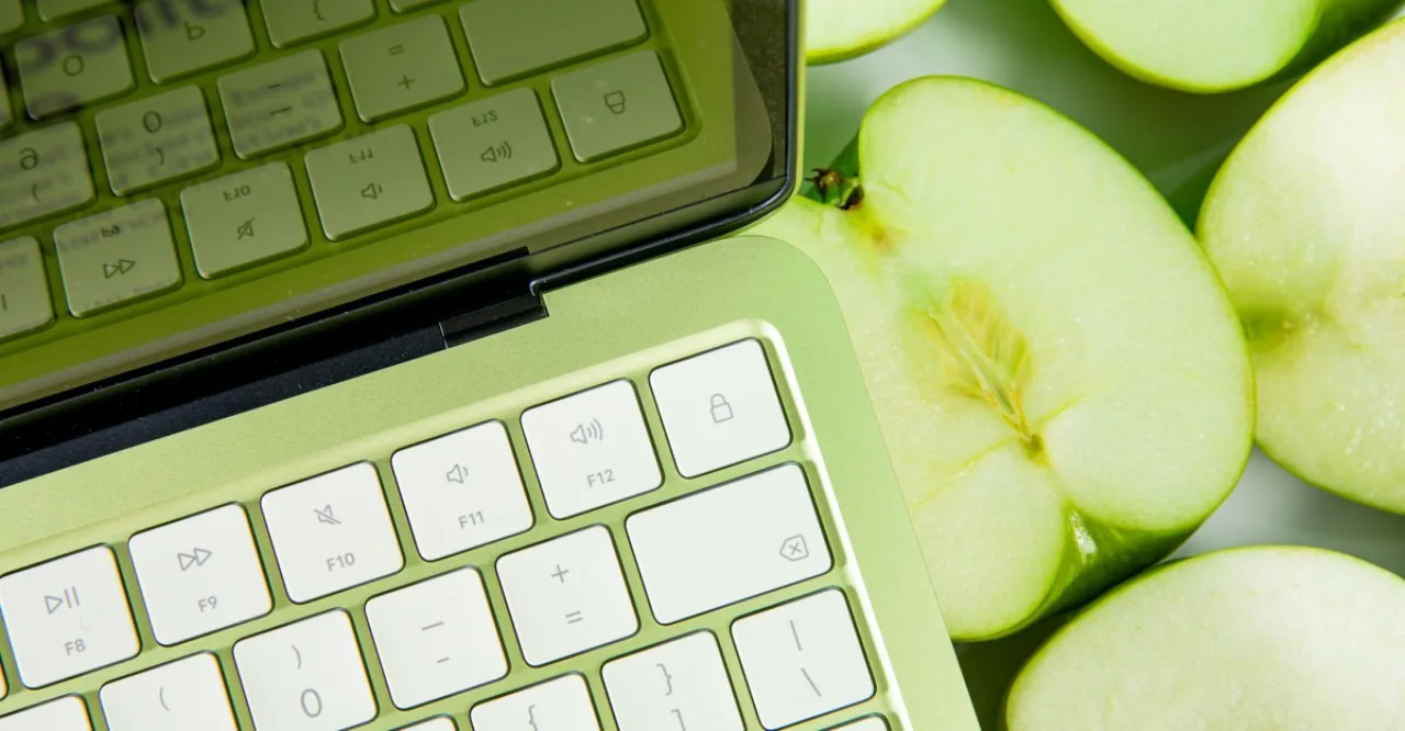 Pessoa segurando iPad enquanto faz alongamento de braço, com maçã verde ao lado e garrafa de água