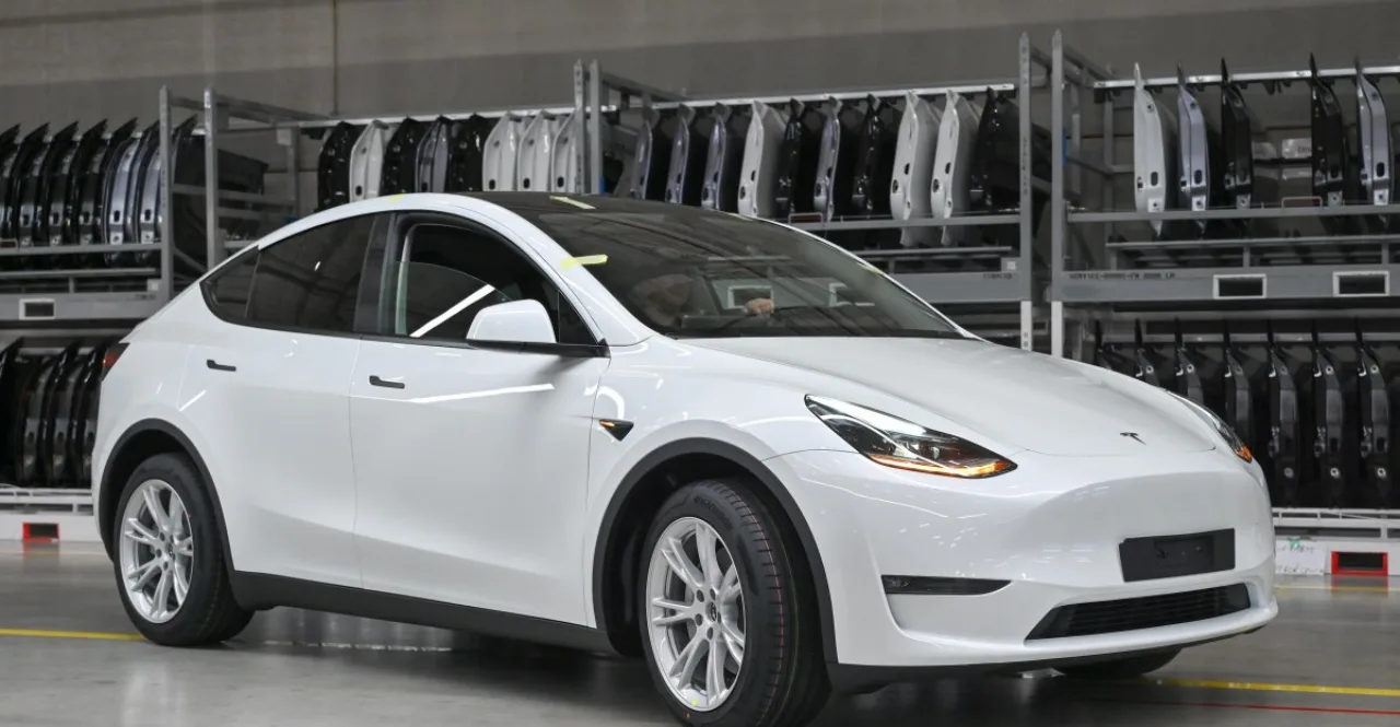 Suspensão de um Tesla Model 3 destacada, com a roda dianteira levantada e componentes metálicos expostos