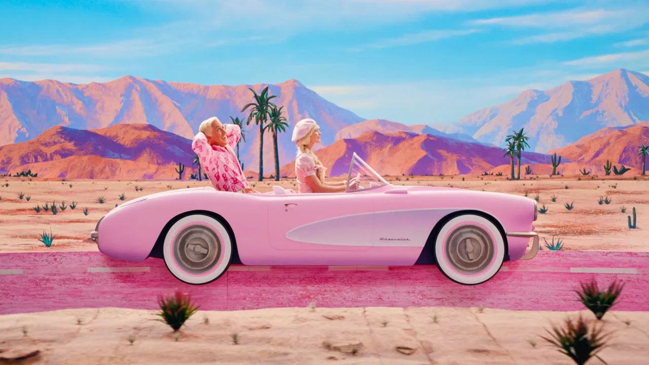 Mulher em roupa de treino levantando halteres rosa ao lado da boneca Barbie em pé sobre um tapete
