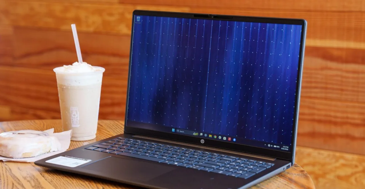 Jovem na esteira, usando HP OmniBook 16 GB para planilha de treino, ao lado de garrafa d'água e halteres