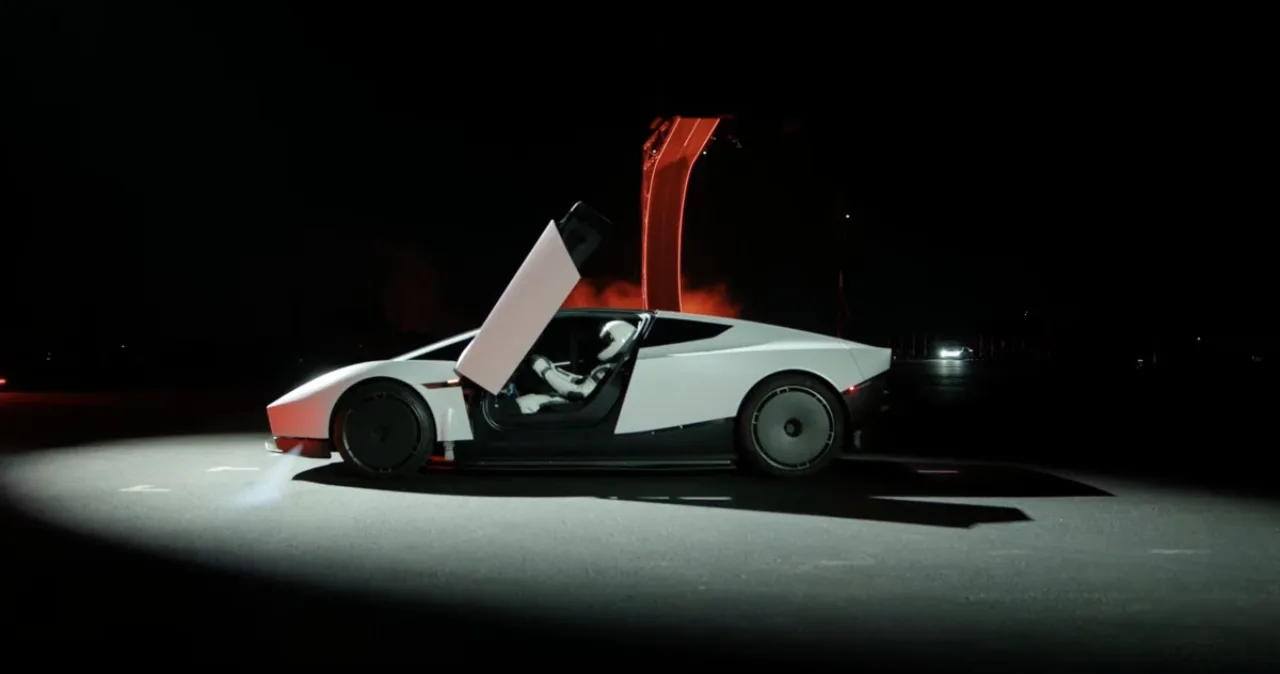 Tesla Roadster vermelho voando sobre o céu de Waco, de cabeça para baixo, com fumaça e o logotipo da Tesla ao fundo