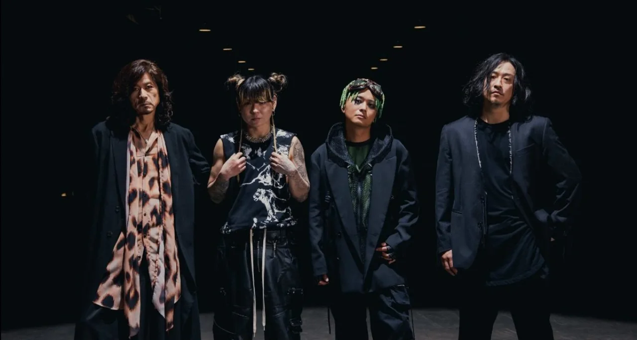 Kenta Uesugi canta ao microfone, cercado por luzes neon e o logo da LEADER ao fundo, com a capa ‘Madman?’ em destaque