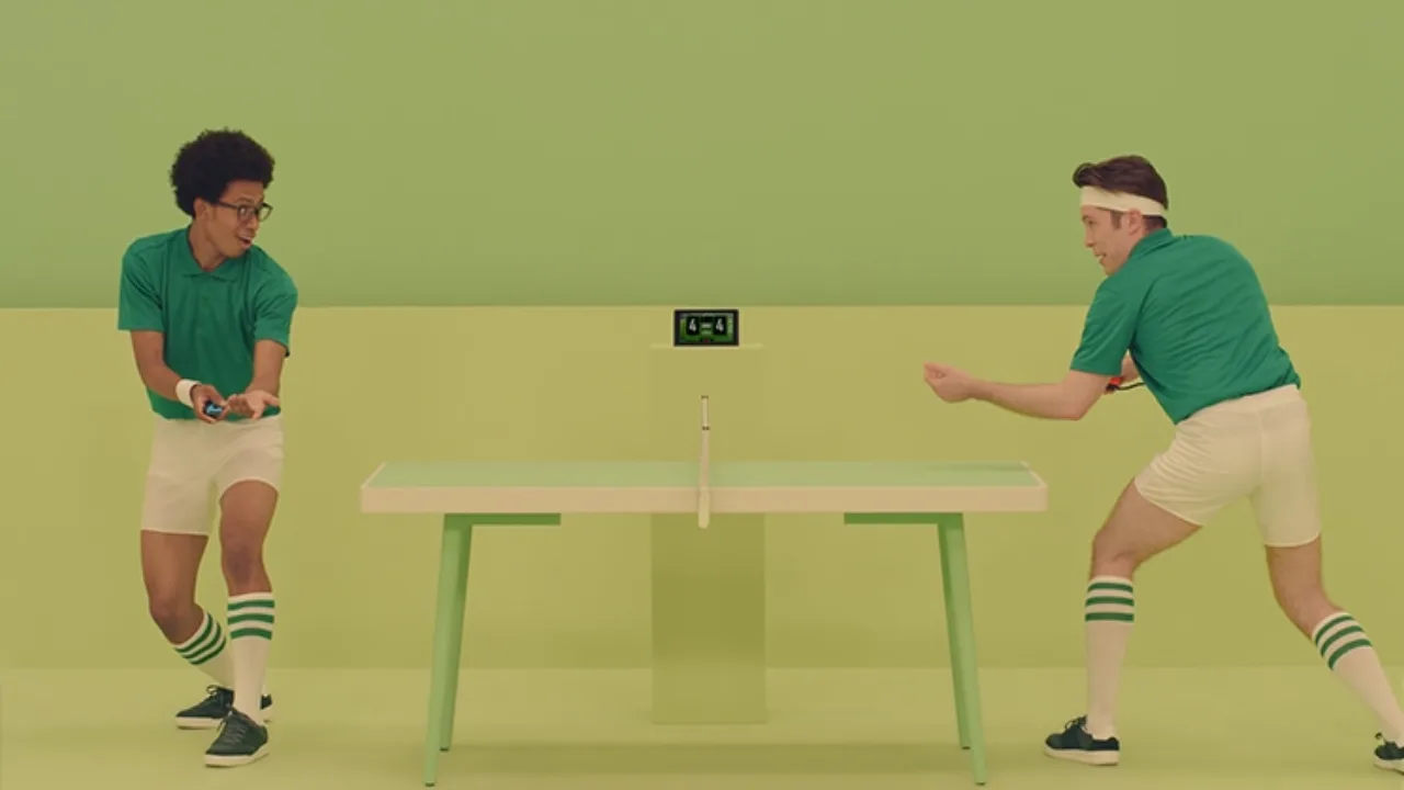 Pessoa em roupa de academia segura o Switch 2 e um cartucho, sentada em um tapete de ioga com garrafa de água ao lado