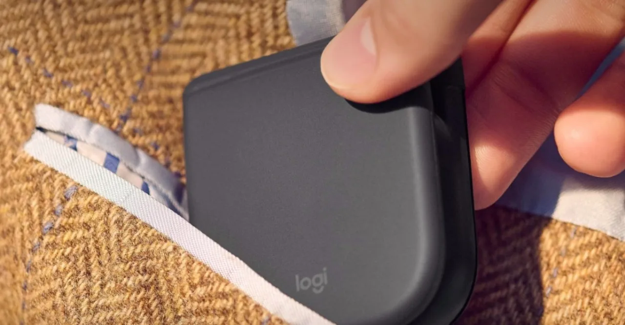 Mão operando mouse dobrável ergonômico com notebook e garrafa de água, focando na postura correta e alívio muscular