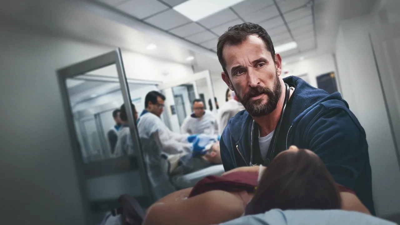 Médico em jaleco fazendo flexão de braço ao lado de uma maca e equipamentos hospitalares