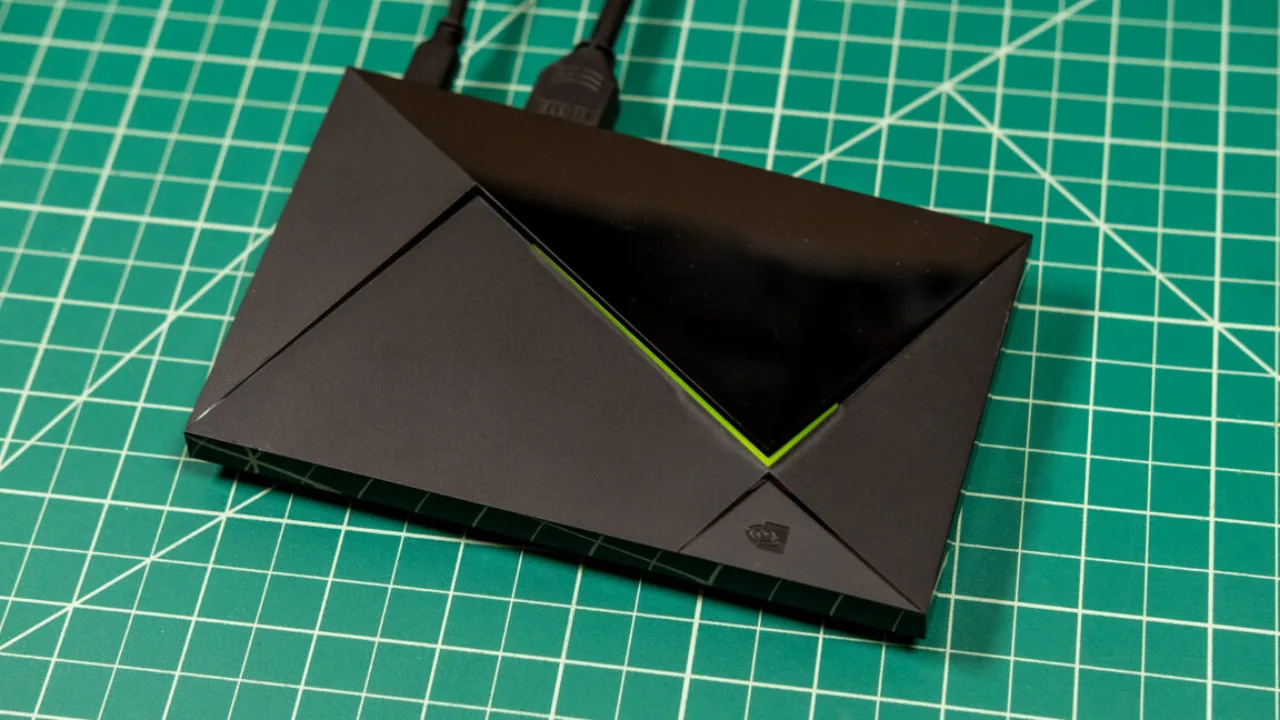 Nvidia Shield TV Pro ao lado do controle, com logo da Nvidia em destaque sobre fundo escuro