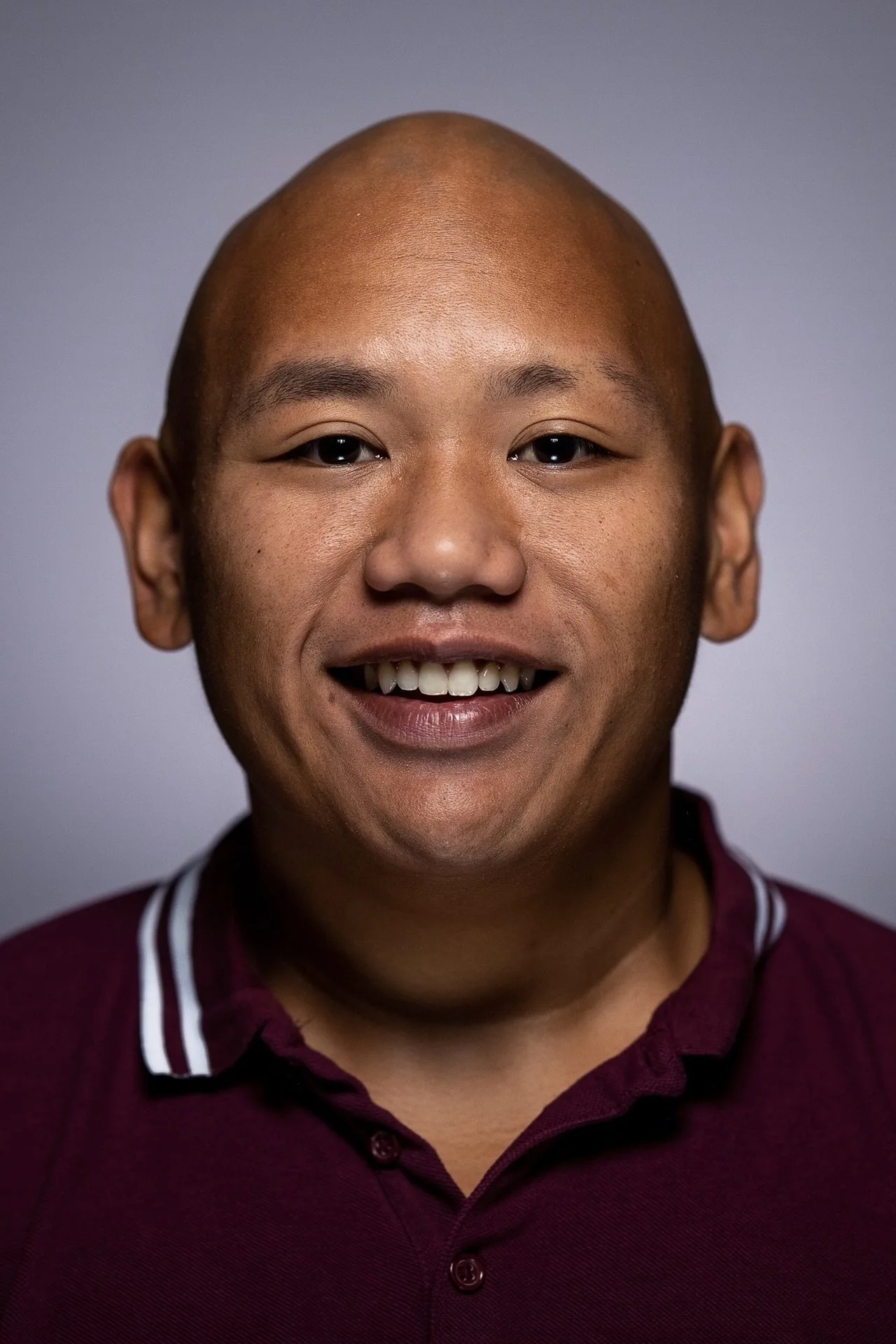 Ned Leeds, de camiseta esportiva, segurando halteres enquanto olha preocupado para um frasco de pílulas