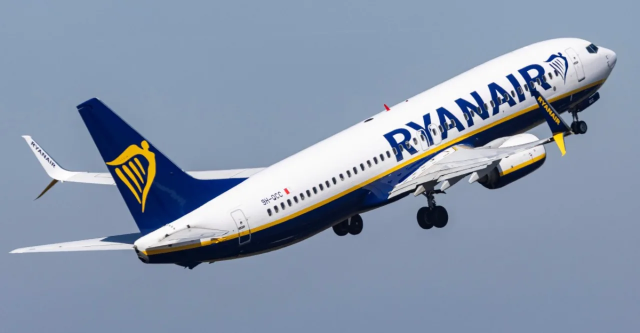 Pais segurando filhos nos assentos de avião, com cintos de segurança e bandeira da Ryanair ao fundo