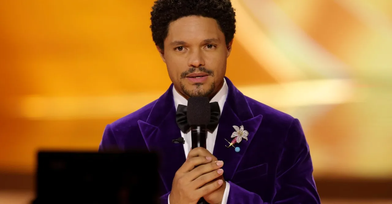 Trevor Noah faz flexões segurando o Pixel 11, com tapete de yoga e garrafa de água ao fundo