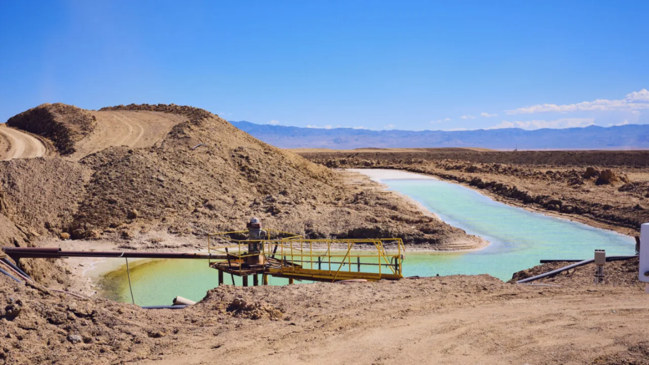 Pilha de baterias de íon-lítio sobre uma bancada de laboratório ao lado de amostras de rochas minerais brutas