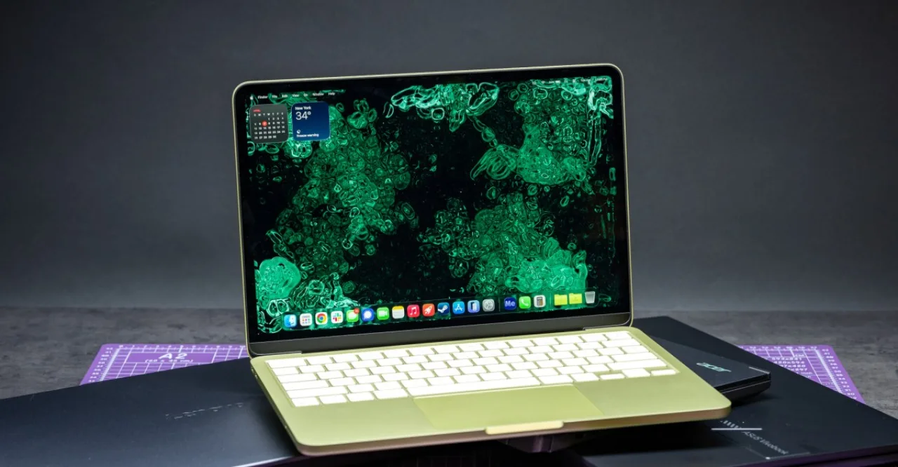 Jovem em roupa de treino, sentado numa esteira, digitando no MacBook Neo aberto ao lado de uma garrafa de água