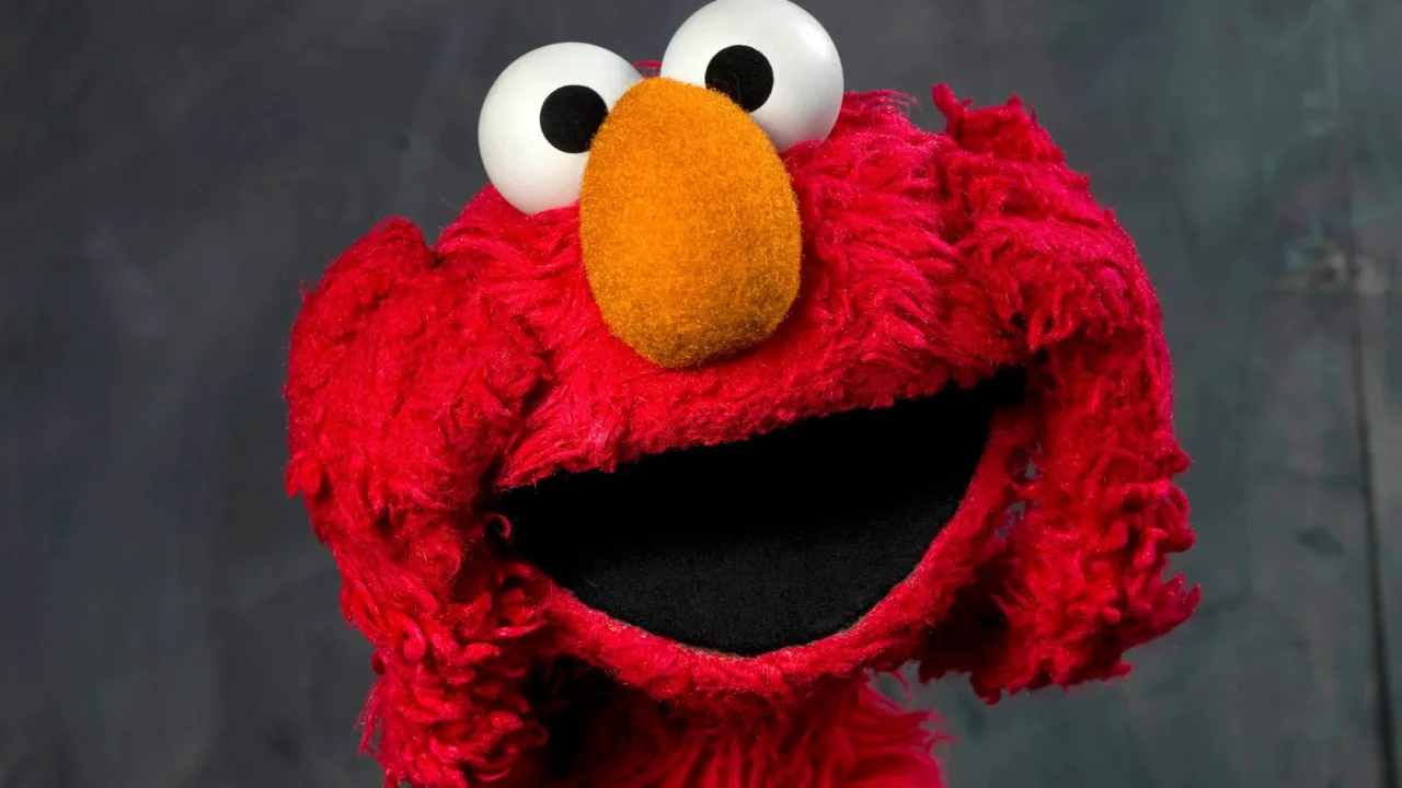 Pessoa em roupa de treino, segurando controle remoto, assistindo ao filme da Sesame Street na TV da Netflix