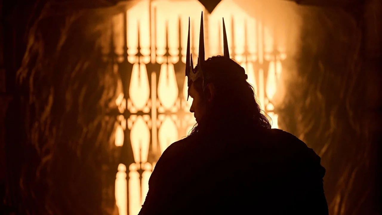 Mulher em leggings faz agachamento, segurando controle da Prime Video enquanto tela mostra Sauron forjando o anel