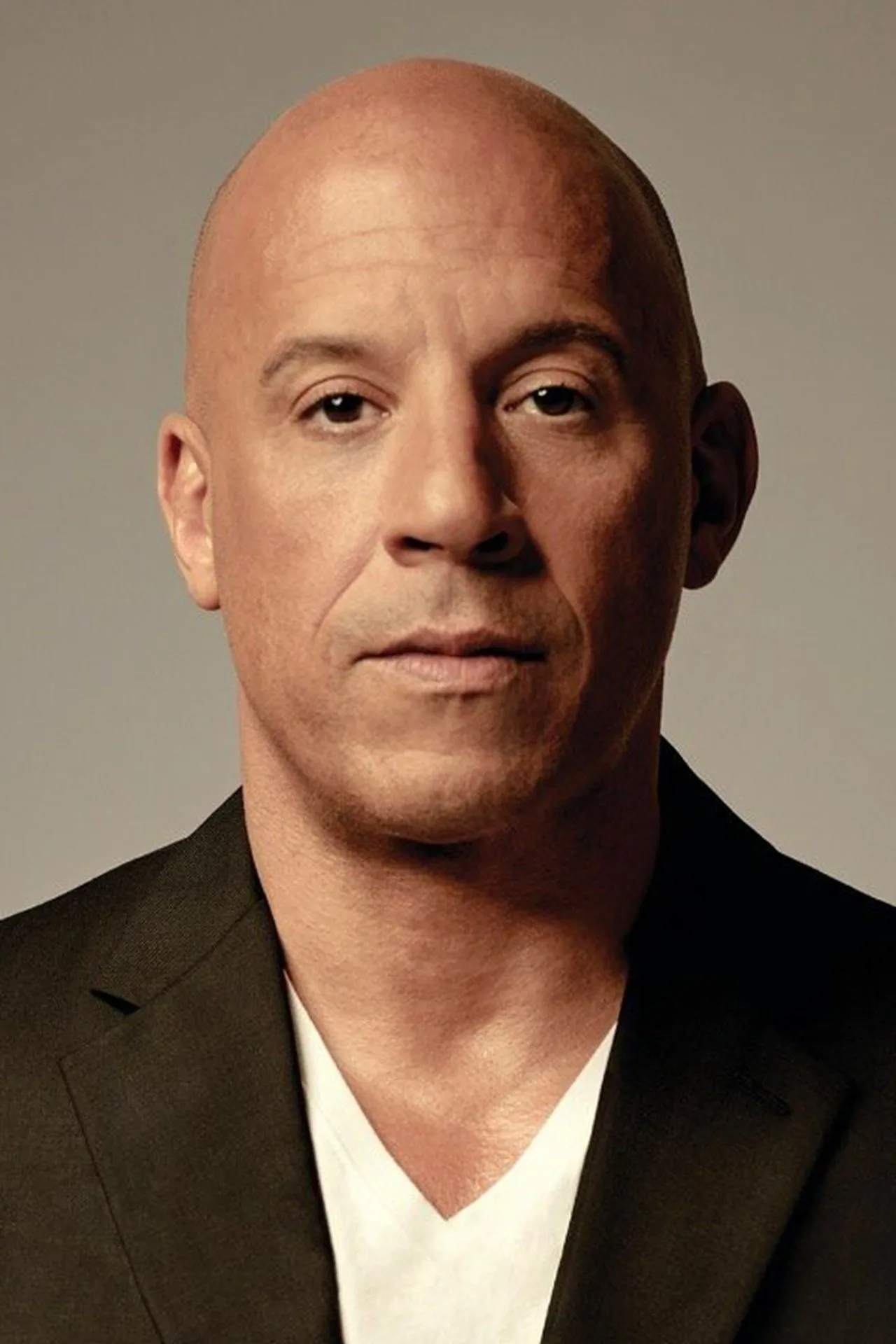 Vin Diesel treina com halteres em academia rústica, exibindo bíceps definidos ao lado de uma garrafa de água e toalha