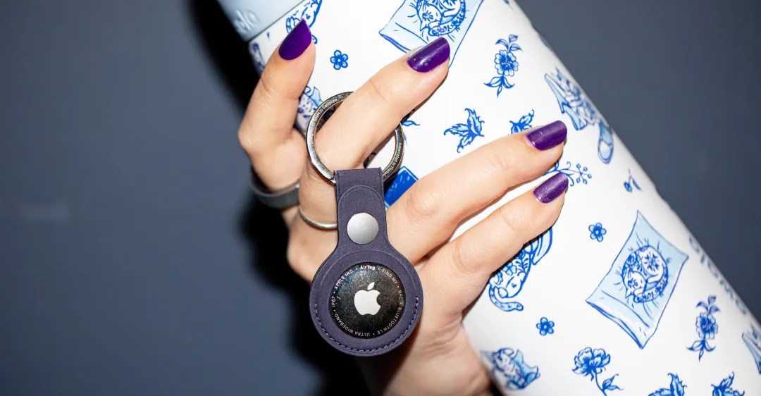 Corredor usando fone Bluetooth, com pulseira fitness e AirTags presos ao cinto de corrida ao ar livre