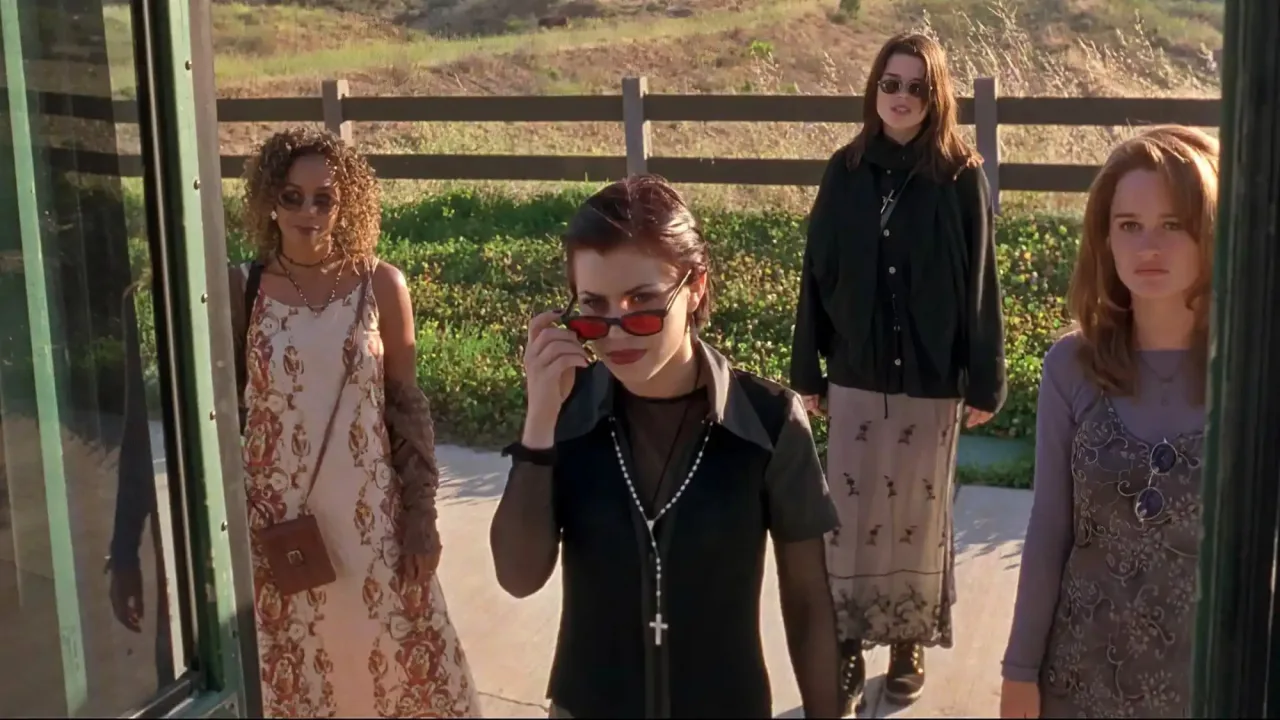 Jovem em roupa de treino faz agachamento ao lado de pôsteres de Scream, The Dentist, Thinner e The Craft