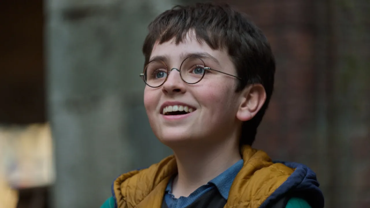 Jovem em roupa de academia segurando um livro de Harry Potter, sentado numa esteira, com um espelho refletindo a capa