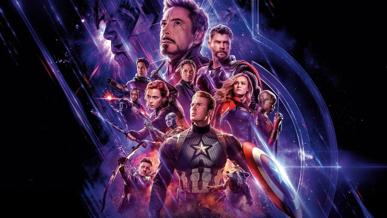 Um atleta em traje de super‑herói levantando peso com halteres ao lado de uma tela exibindo o logo de “Avengers: Endgame”