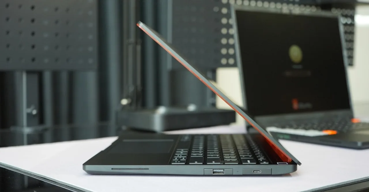 Atleta correndo na esteira, segurando o Framework Laptop 13 Pro com SSD 1 TB, água e tênis de corrida ao lado