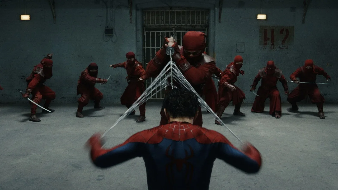 Tom Holland em roupa de treino, segurando um kettlebell ao lado de um traje de Spider‑Man sobre um tapete